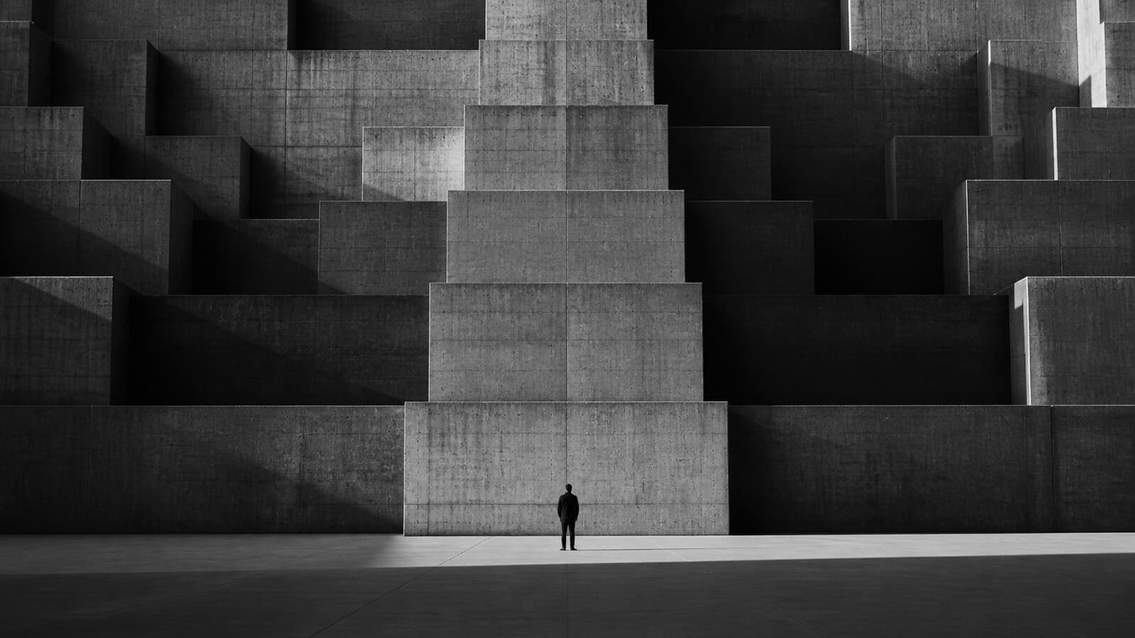 A small figure beside monumental concrete architecture